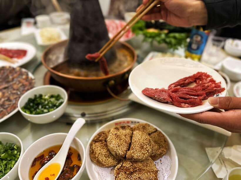 Beijing Hutong Food Crawl Delights: Peking duck, Hotpot&More - Mongolian hot pot in a copper pot over charcoal: where the dipping sauce steals the show